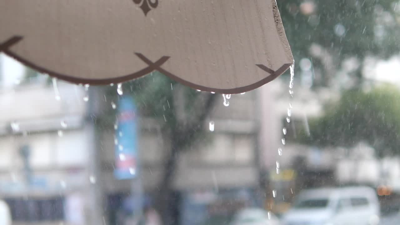 Rainy day scene with water dripping from umbrella