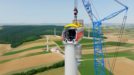 crawler crane and workers assembling nacelle of wind turbine at the wind farm