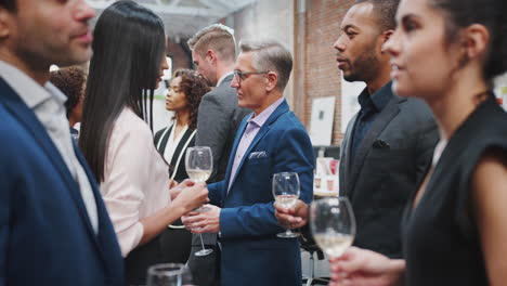 business team socializing at after works drinks in modern office