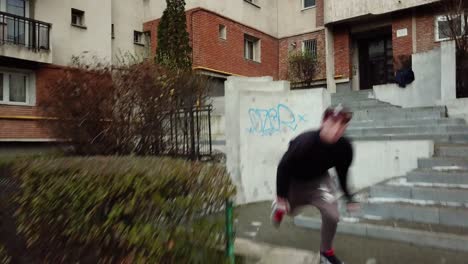 leading tracking shot of a young adult male parkour free runner vaulting walls