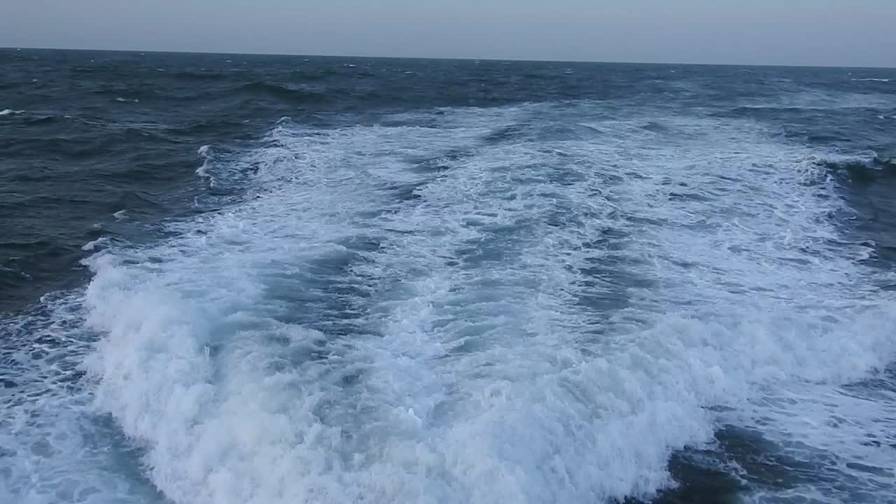 맑은 하늘 날, 푸른 바다, 수면에서 빠르게 움직이는 모터 보트 뒤에서 보이는 물의 여파