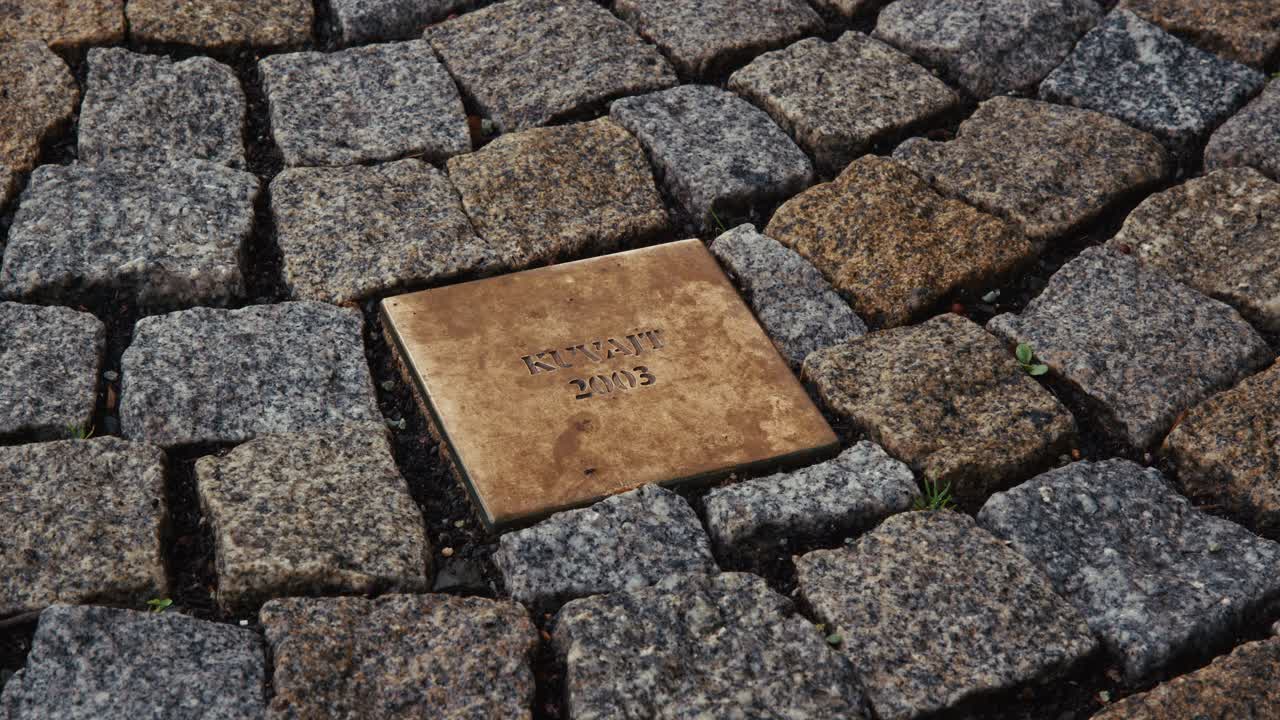 Bronze plaque embedded in cobblestone pavement in Bratislava