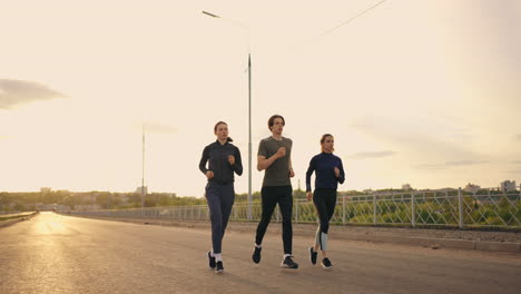 three-runners-are-preparing-to-marathon-two-women-and-man-are-jogging-in-sunset-or-sunrise