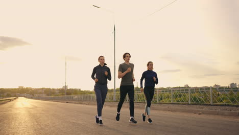 three runners are preparing to marathon two women and man are jogging in sunset or sunrise