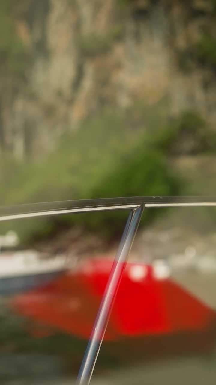 cercas soleadas en un barco de motor moderno que navega hacia el puerto marítimo al pie de la montaña escarpada. yate de lujo en la laguna oceánica en el balneario. transporte acuático para turistas