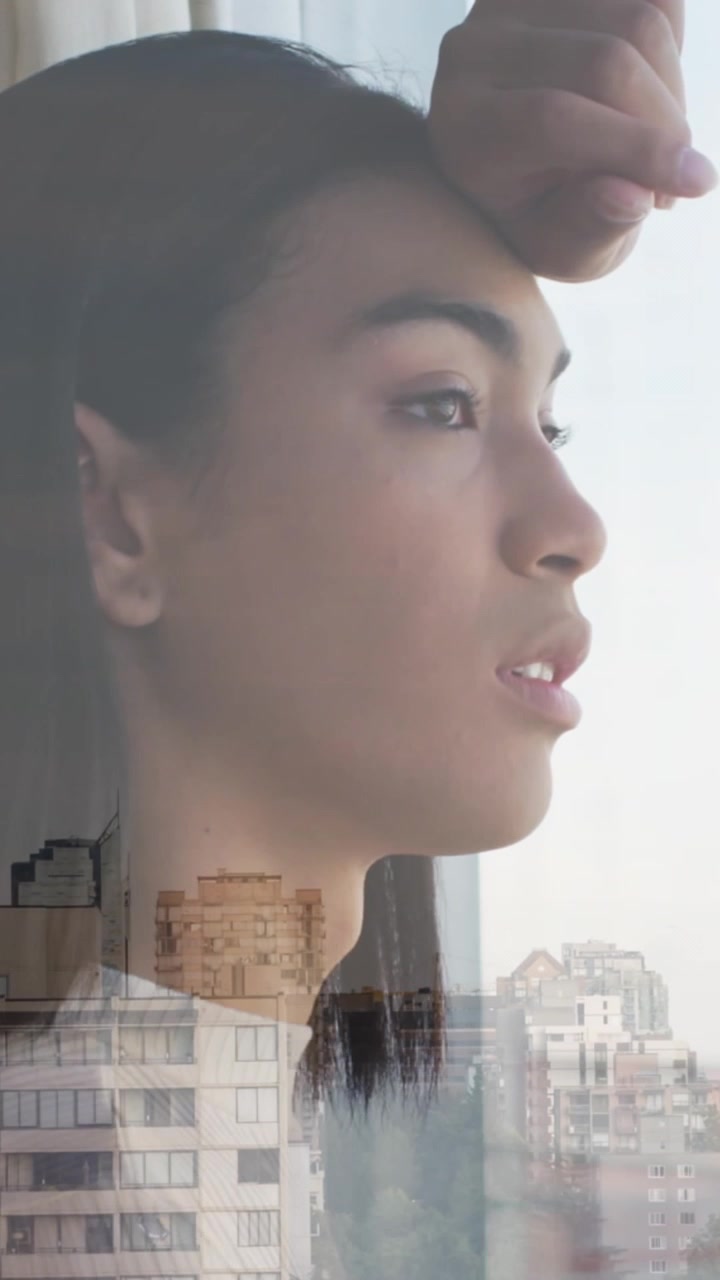 Animation of cityscape over woman looking through window