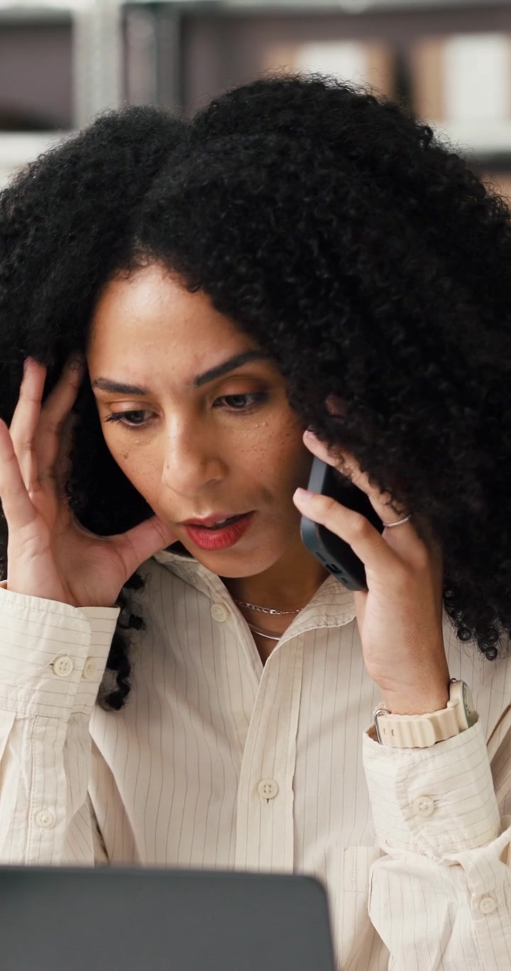 Stressed Businesswoman Talking on Smartphone in Office