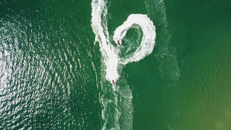 bird's eye view of water scooters doing stunts and tricks