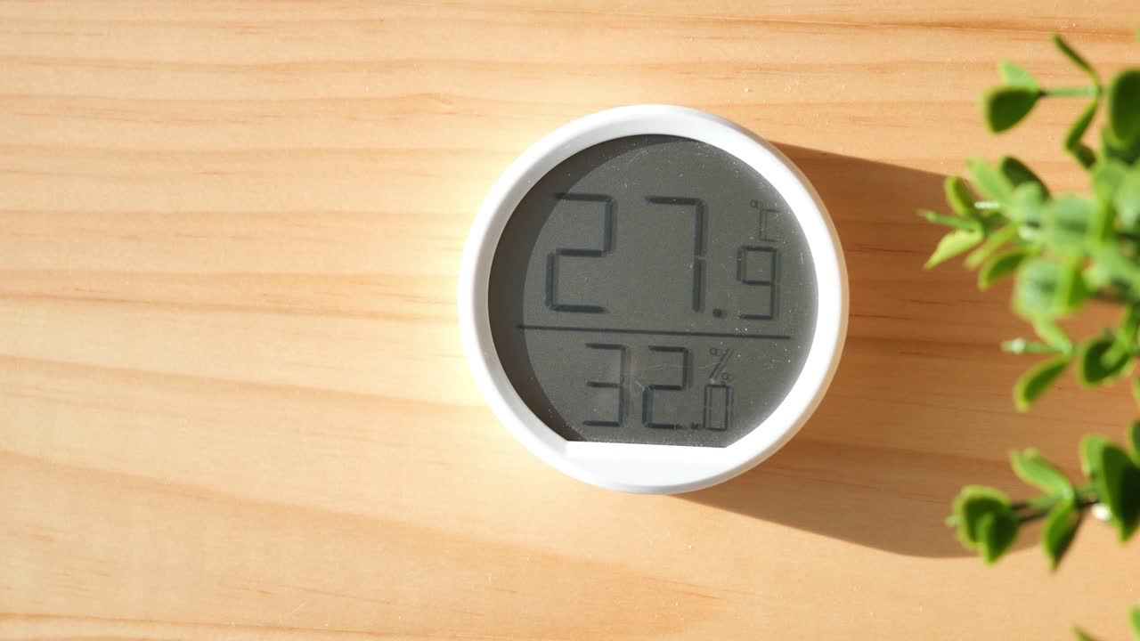 higrómetro y termómetro digitales en mesa de madera