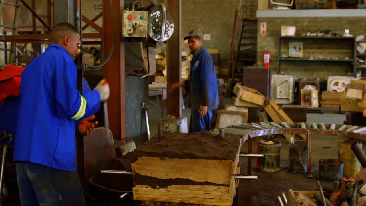 Worker removing excess soil from wooden mold 4k