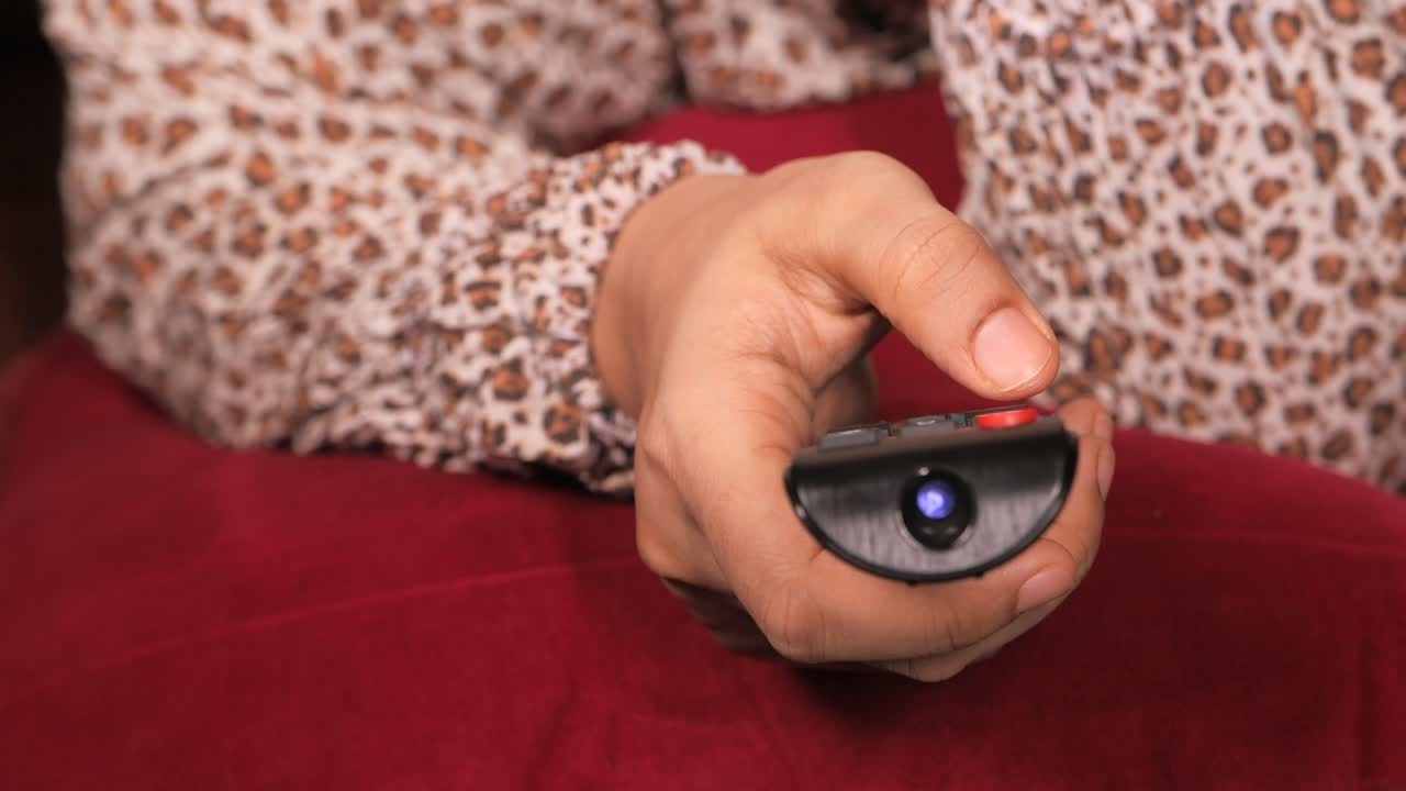 tv 를 보기 위해 리모컨 을 사용하는 여자