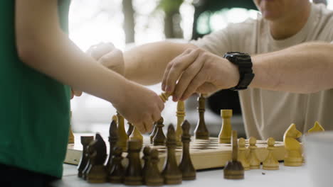 close up of father and son setting up a chess board