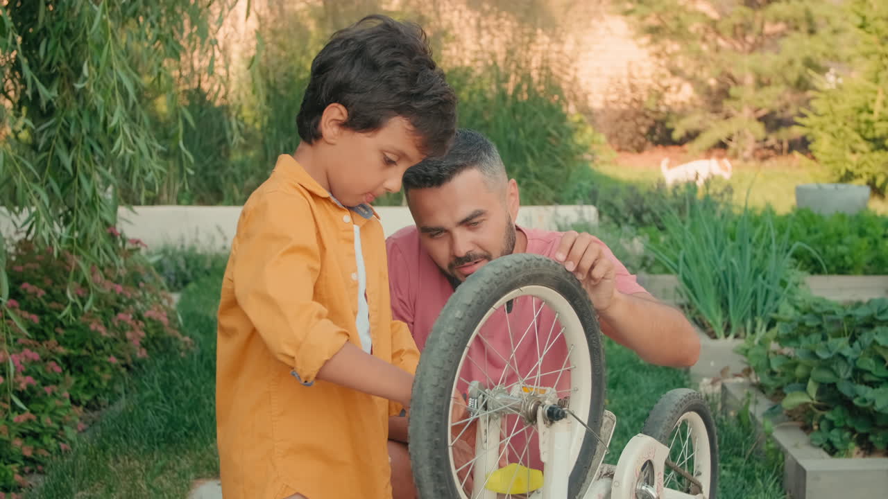 Dad And Son Repairing Bike On Summer Day