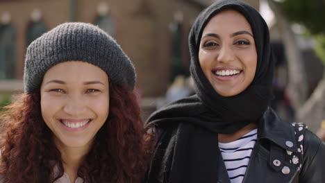 portrait of two young multi ethnic woman friends laughing happy at camera enjoying relaxed lifestyle