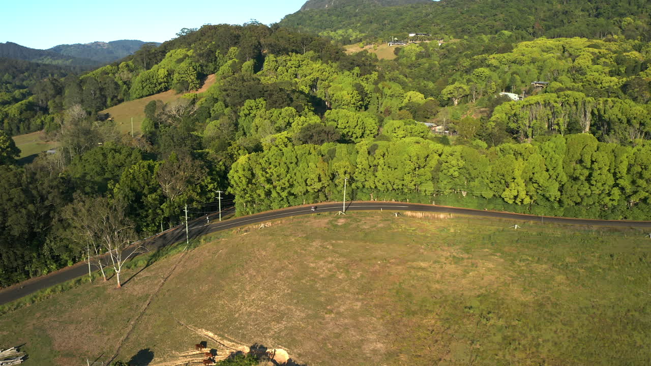 amplia toma aérea de un ciclista que va cuesta abajo en medio del campo