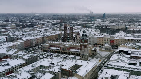 snow-covered old town (krakow city center - main square, sukiennice - cloth hall and town hall) at cloudy morning, krakow, poland