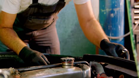 mecánico masculino haciendo servicio a un coche 4k