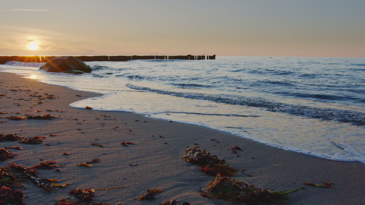 Beach with small waves while beautiful sunset, wide angle, 4k