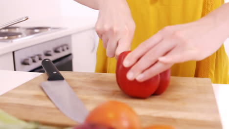 close up on a woman carving sweet pepper