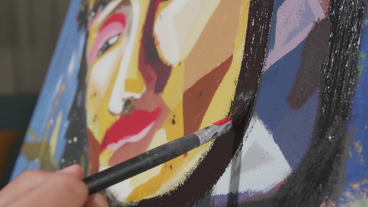 Close Up Of A Hand Holding Paintbrush Mixed Colour And Painting A Girl'S Face On The Canvas