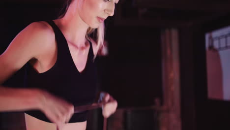 Tilt-Up-Shot-Of-Slim-Female-Athlete-Doing-Shoulder-Exercise-With-Resistance-Band-At-Health-Club