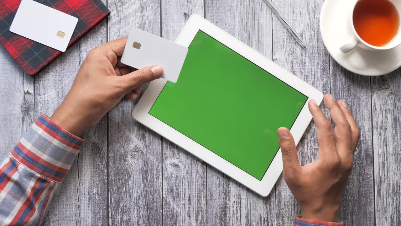 hombre que usa una tableta para comprar en línea con tarjeta de crédito