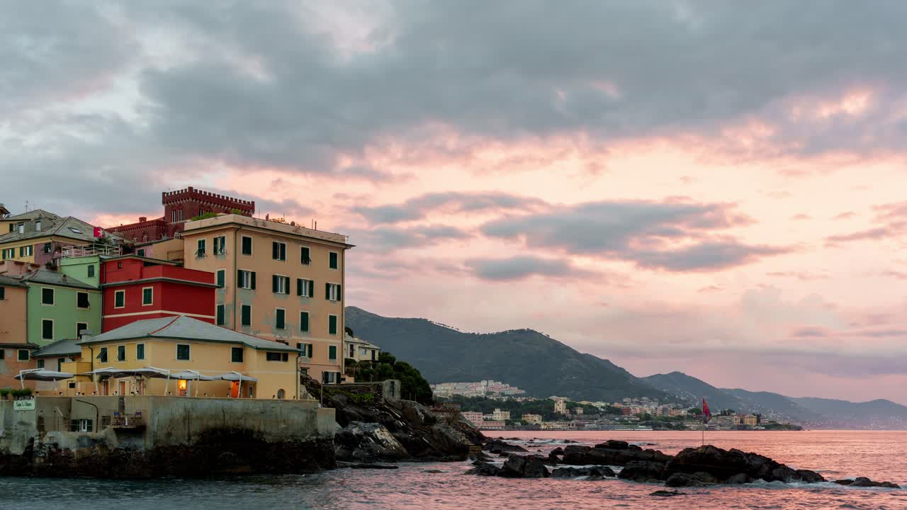 Colorful seaside buildings in Boccadasse, Genoa as the sun sets over the Mediterranean sea