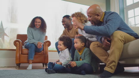 Mehrgenerationenfamilie-Zu-Hause-Im-Wohnzimmer,-Während-Enkelkinder-Gemeinsam-Computerspiele-Spielen