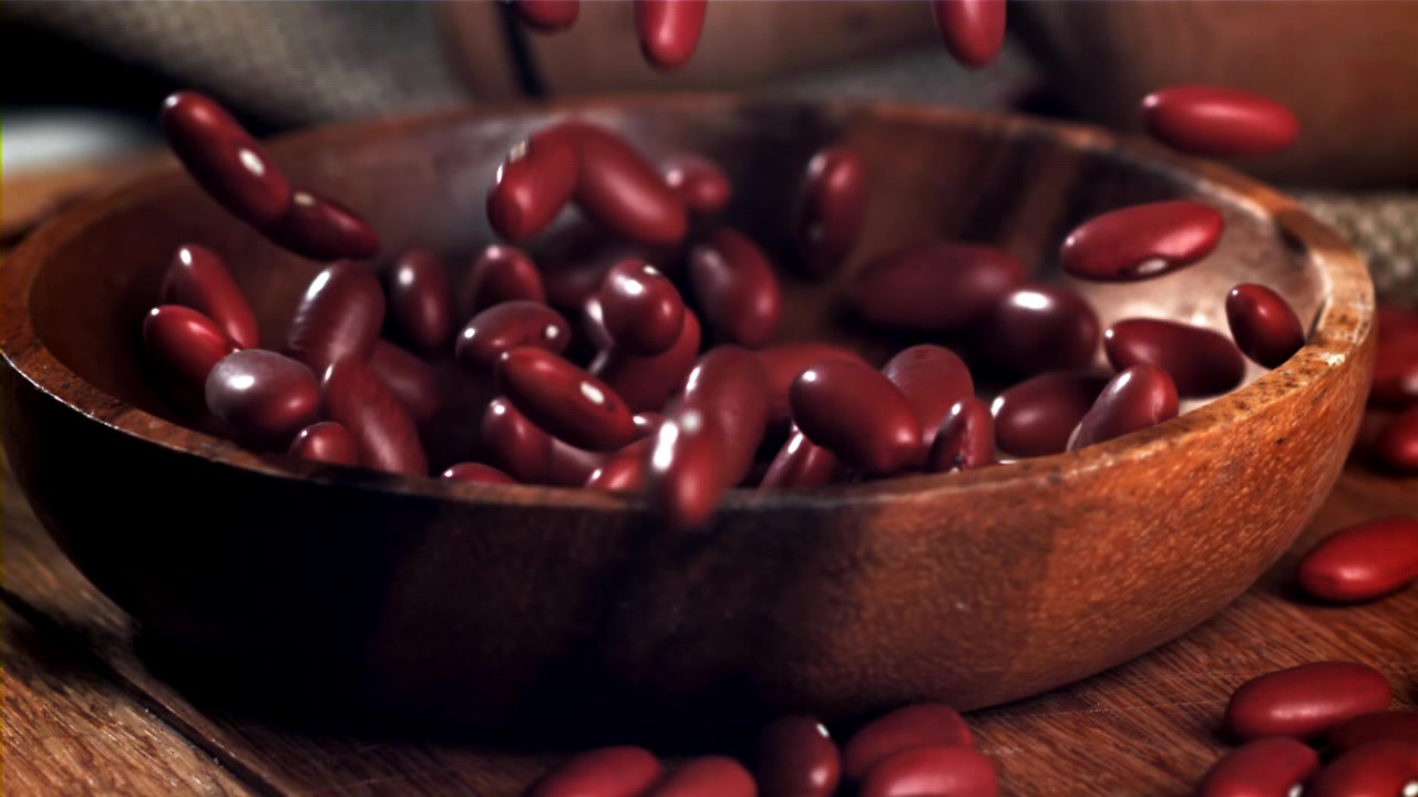 Red Kidney Beans Falling into a Wooden Bowl in Slow Motion