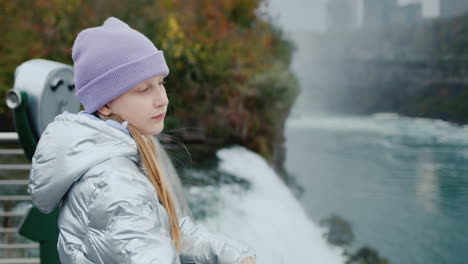 a child admires the spectacular view of the niagara river, stands at the famous niagara falls