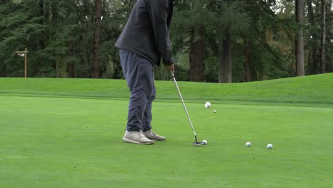 person does a practice golf putt