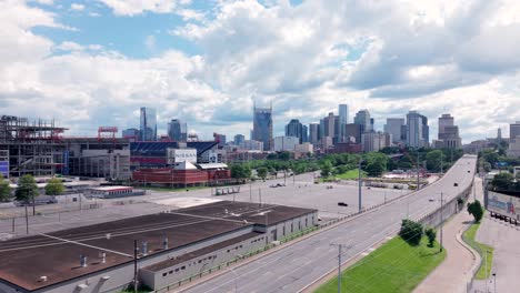 a highway leading to nashville, tennessee with the city skyline in the distance - rising aerial view