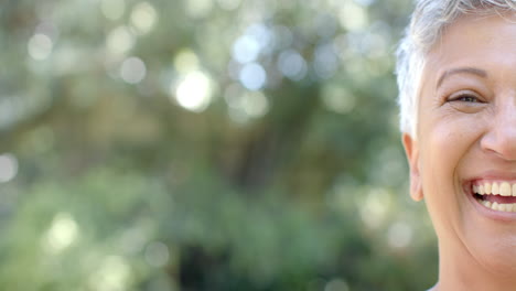 Portrait-of-happy-senior-biracial-woman-in-sunny-garden-at-home,-copy-space,-slow-motion