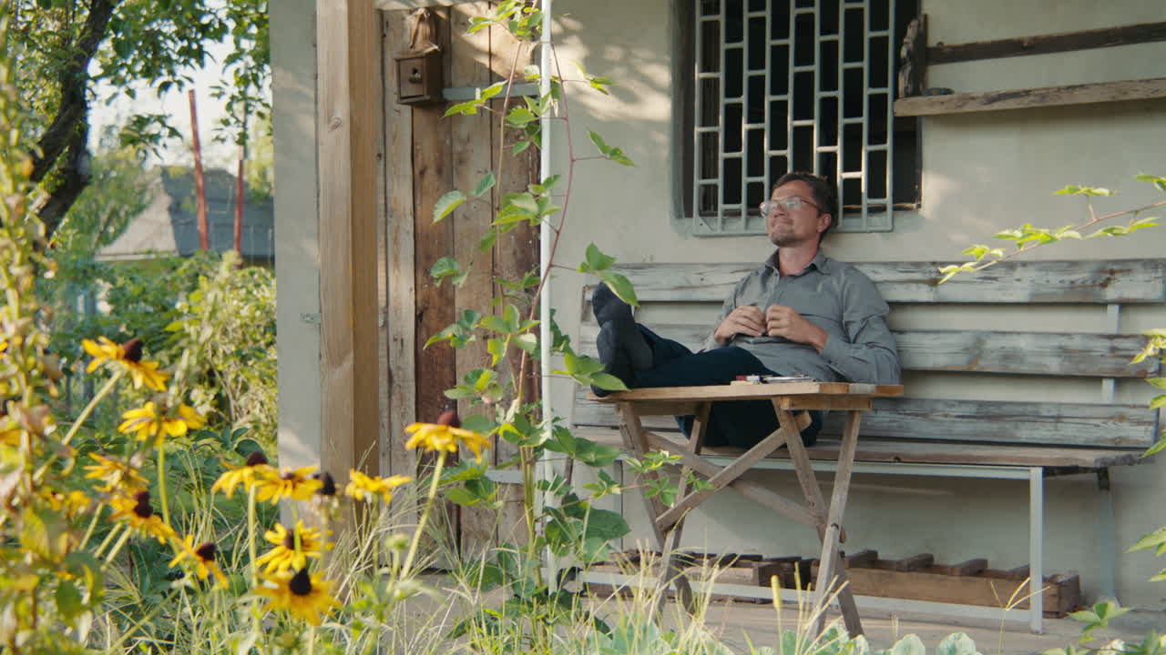 Man relaxing on a porch in a garden