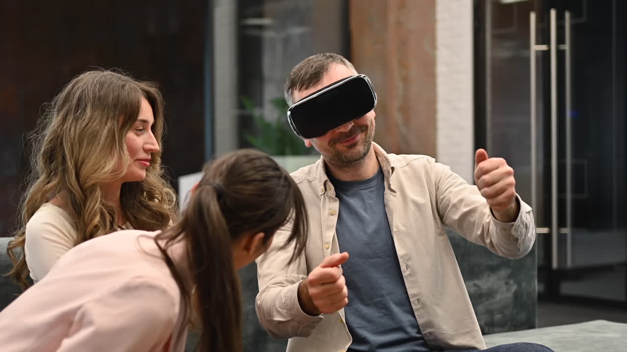 Due donne parlano con un uomo che usa un visore per la realtà virtuale