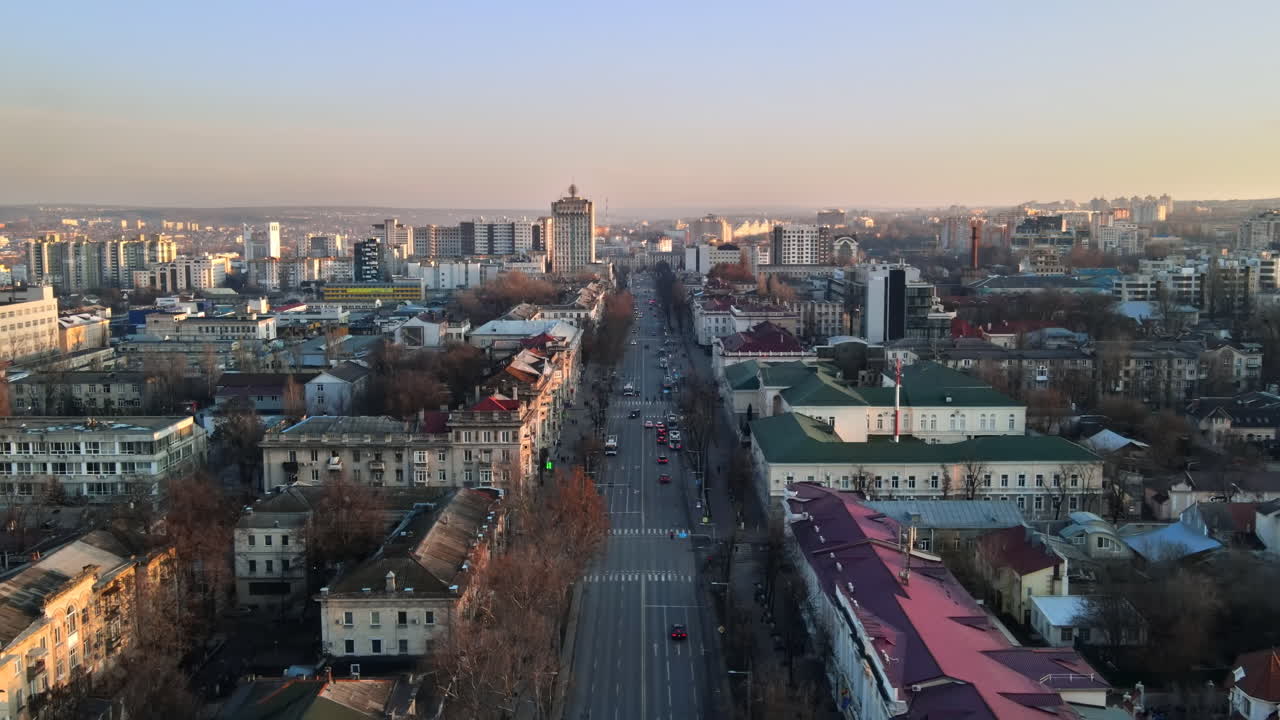 Aerial drone view of Chisinau downtown. Panorama view of a street with multiple buildings, road with moving cars and bare trees. Moldova