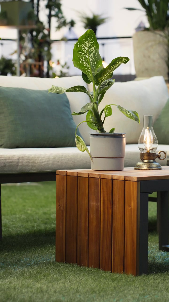 Vertical video Empty rooftop terrace with lounge seating, plants and wooden furniture