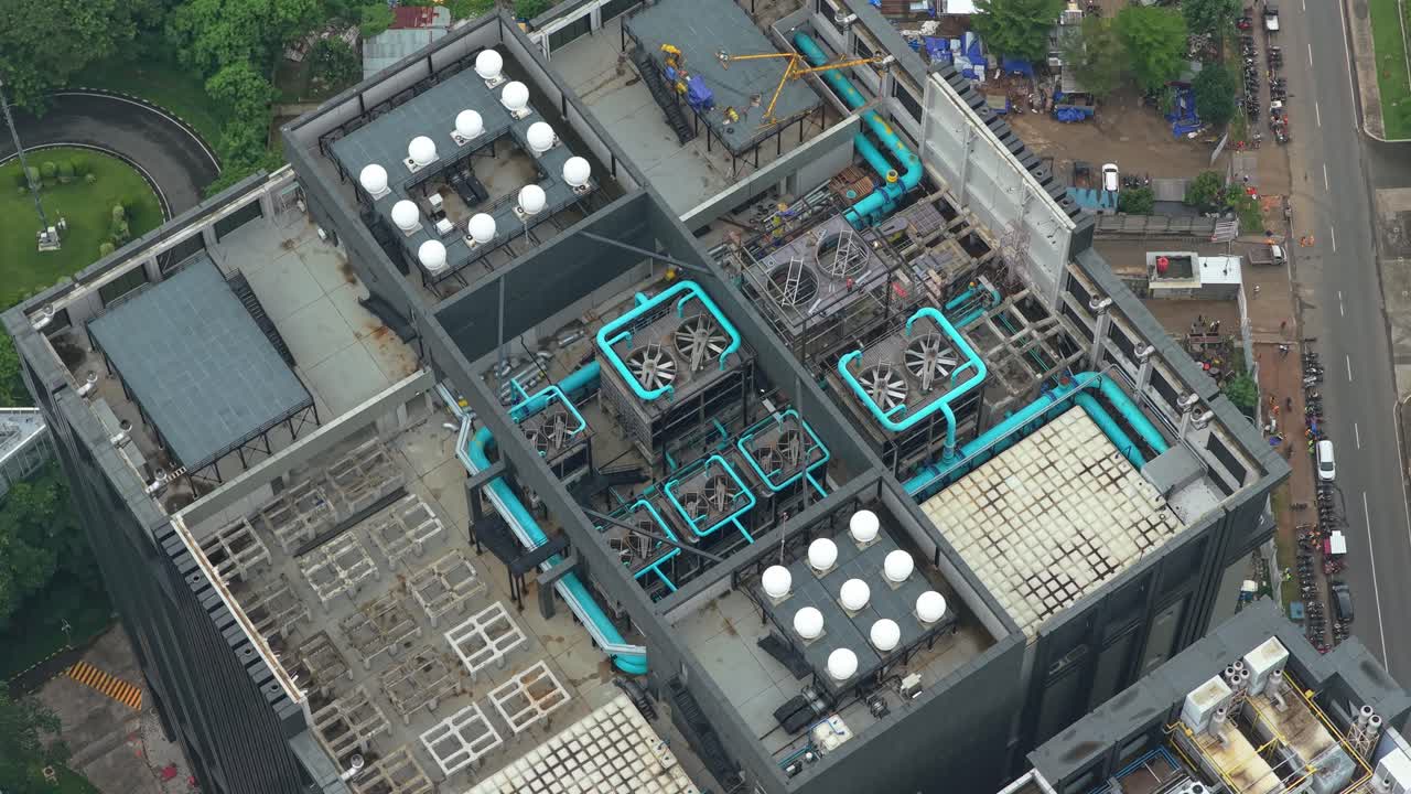 High angle aerial shot revealing the complex hvac and cooling systems on the rooftop of a modern data center building in jakarta, indonesia