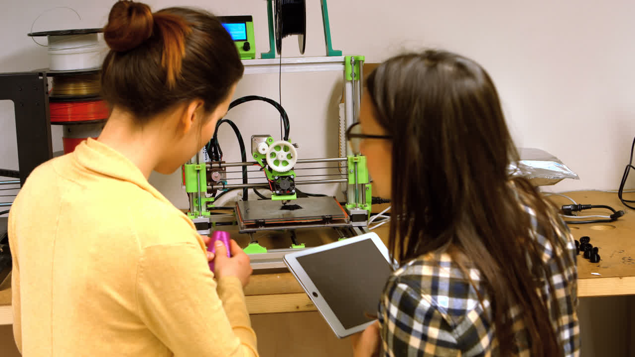 dos diseñadoras gráficas interactuando a través de una tableta digital