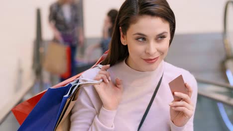 woman with credit card and shopping bags during big shopping