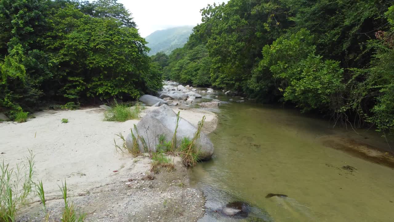 la exuberante vegetación aérea vuela sobre el arroyo rocoso en santa marta, colombia