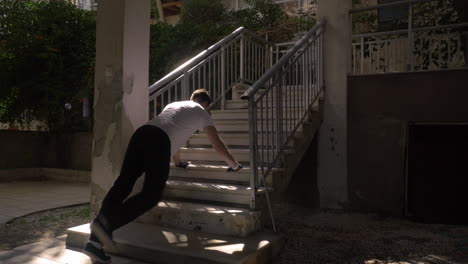 man doing push ups at the outdoor staircase