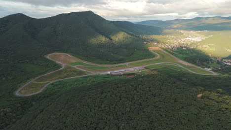 panorámica aérea sobre salta, pista de carreras de montaña boscosa de argentina, autódromo martín miguel de güemes