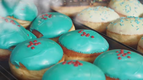 close-up of blue glazed donuts with red sprinkles