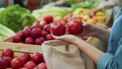 person selecting fresh apples at a market