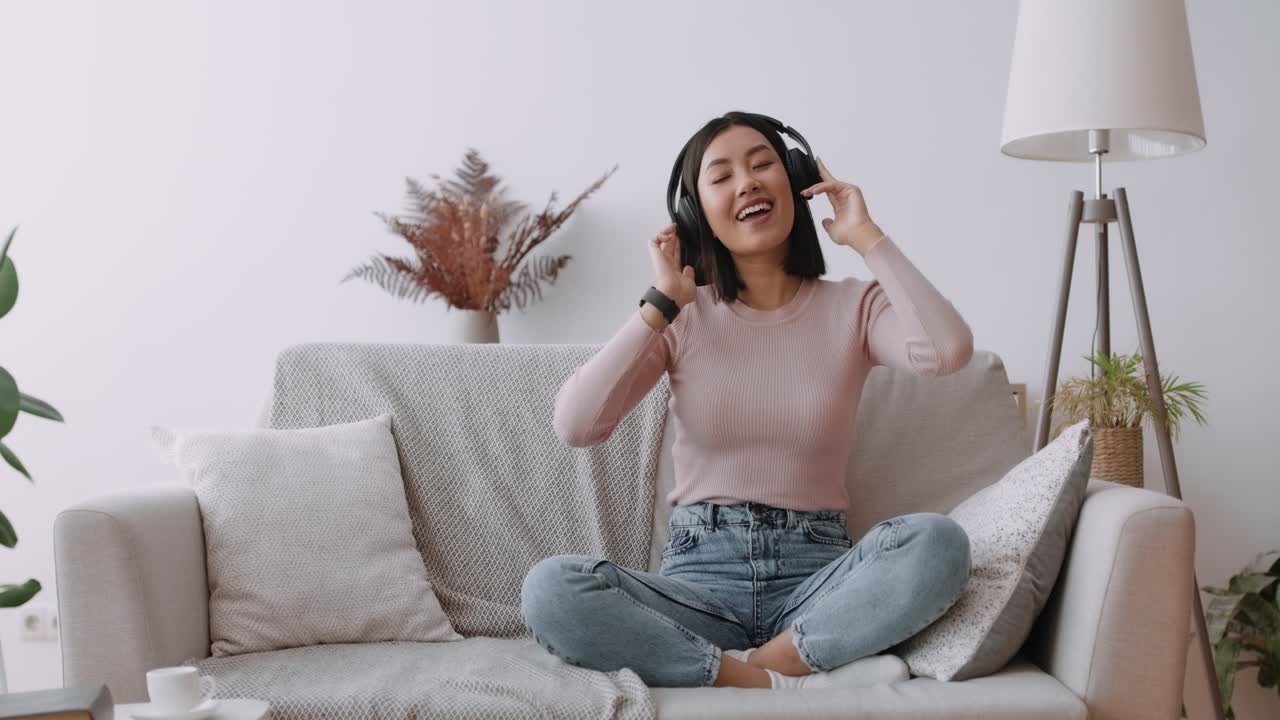 소파 에서 음악 을 즐기는 여자
