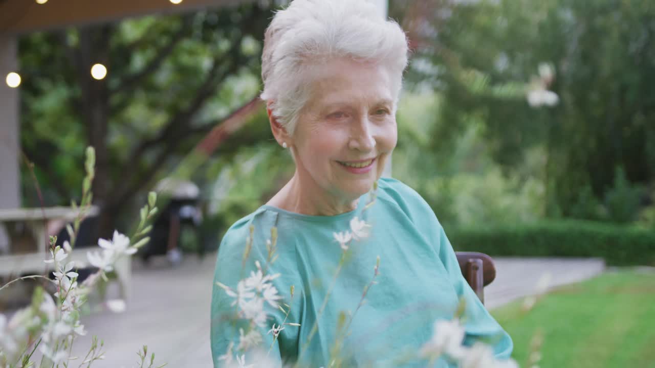 старшая кавказская женщина улыбается и проводит время в саду