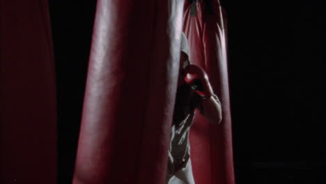 a man dances around while punching a heavy bag