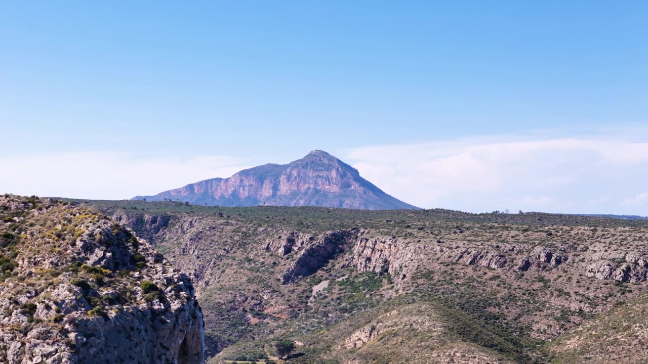 Paesaggio costiero roccioso mozzafiato con sfondo montuoso nell'ambiente naturale della Spagna.