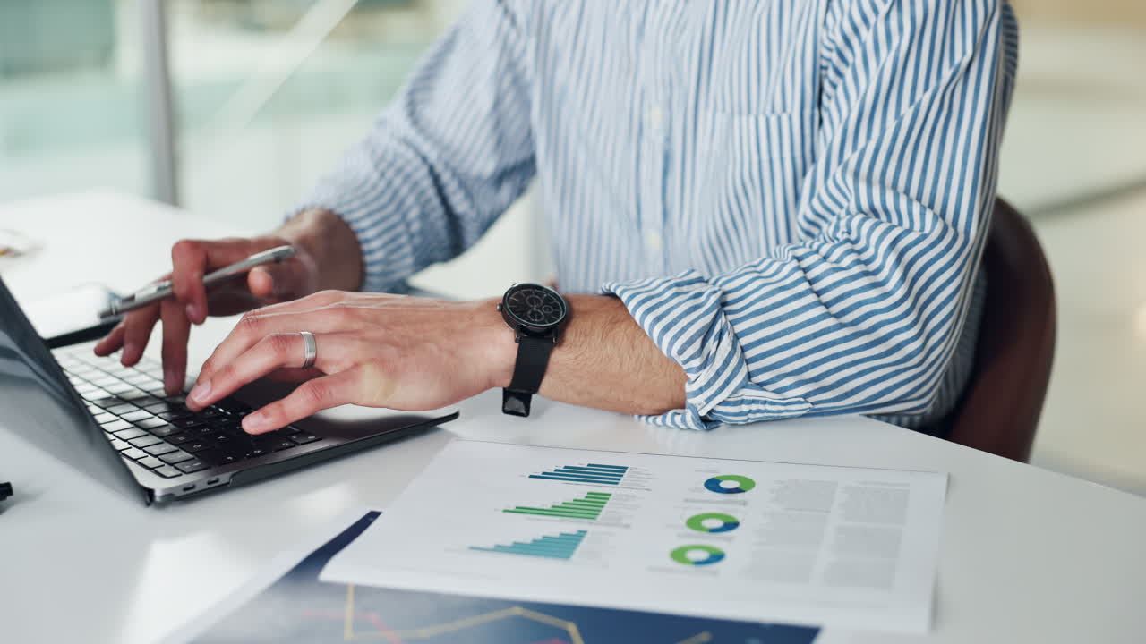 Uomo d'affari che lavora con un portatile e grafici finanziari